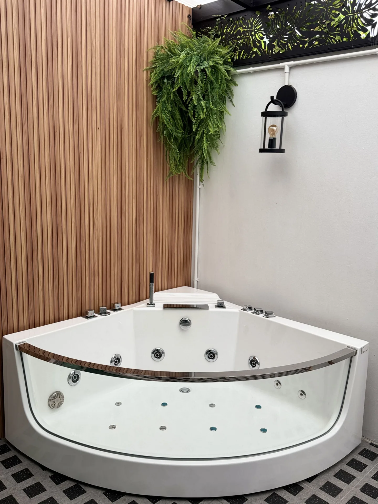Corner jacuzzi beside a wood-panelled wall
