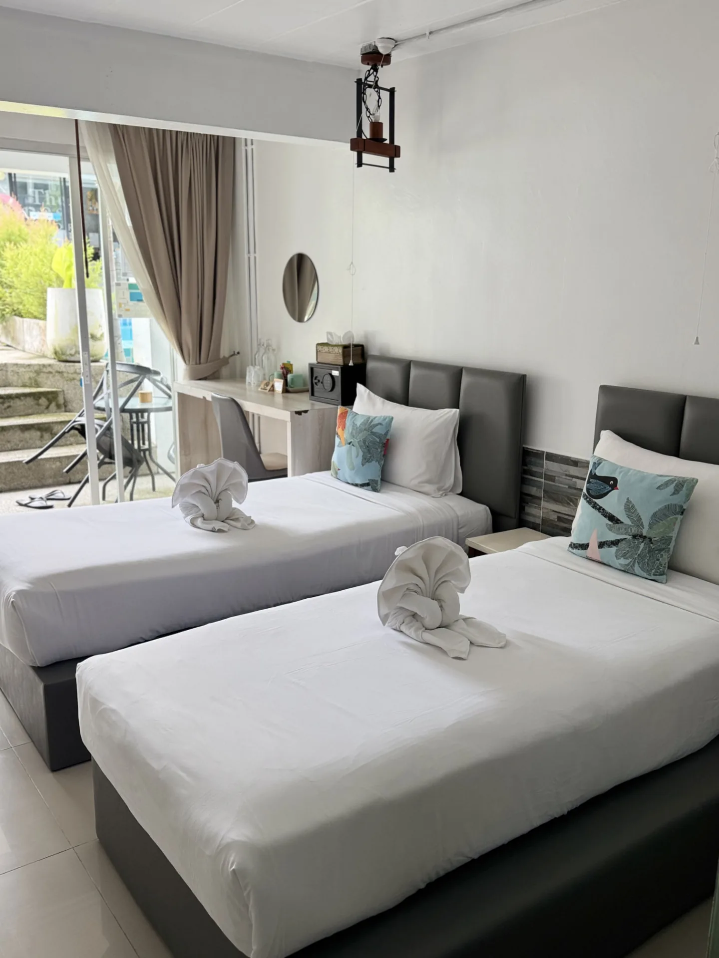 Twin room with two single beds, a desk and a door to the balcony