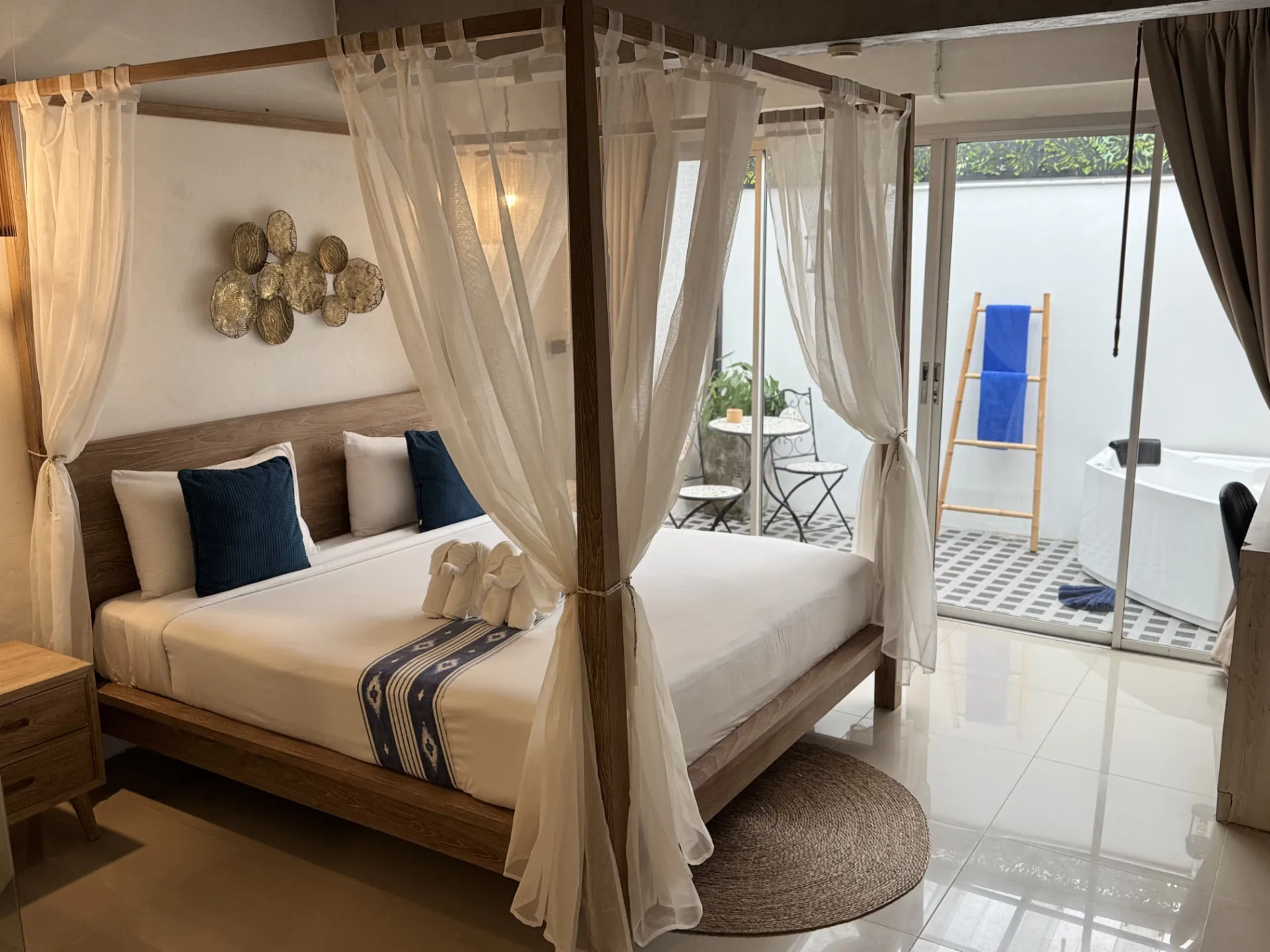 Deluxe room with a wooden canopy bed opening onto a private terrace with an outdoor jacuzzi