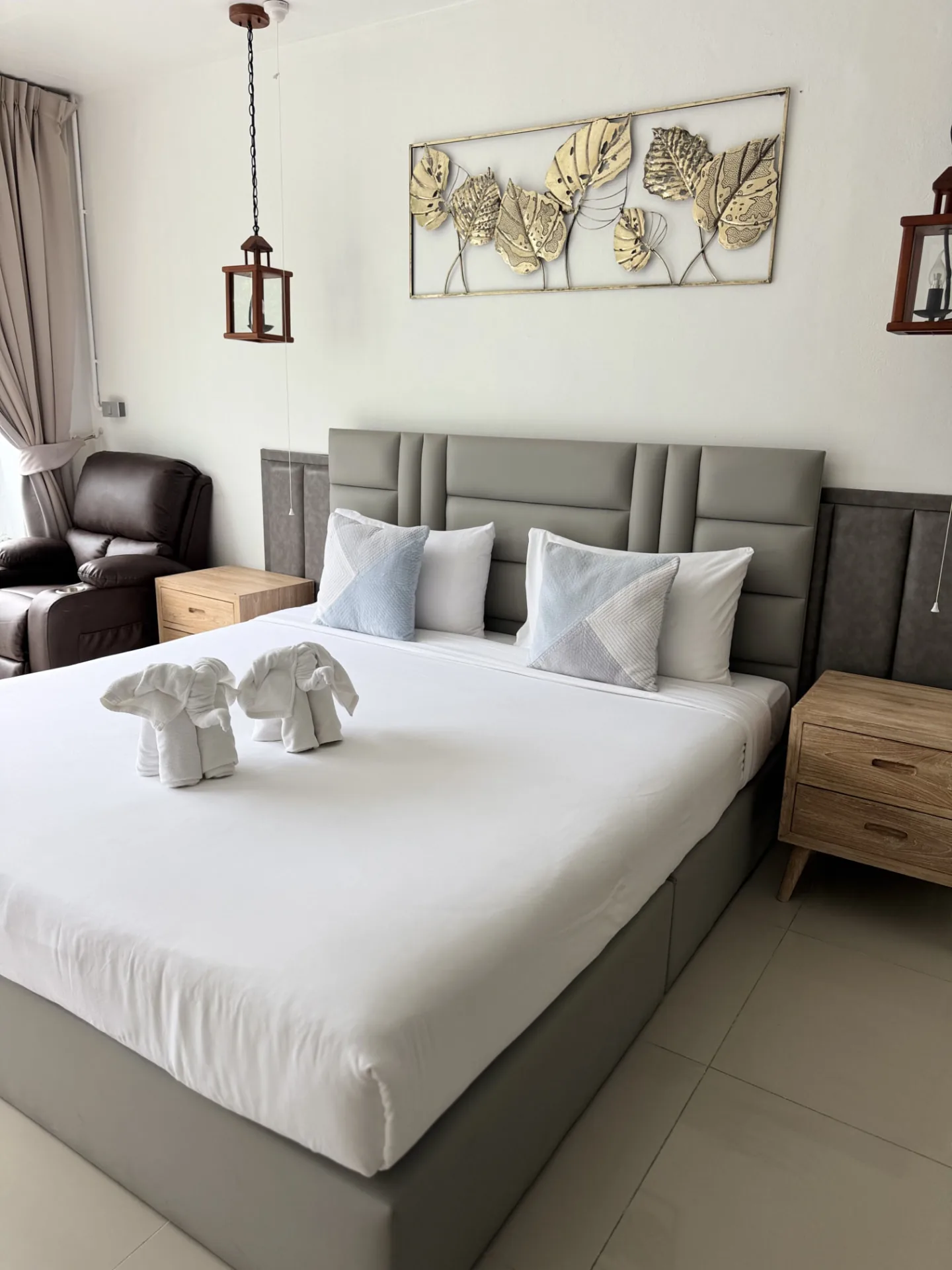 Deluxe double room with a grey upholstered headboard and wooden bedside tables